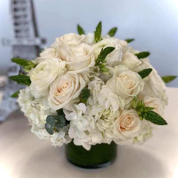 Cream roses and white hydrangeas in a dark green vase