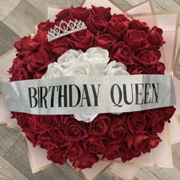Heart-shaped bouquet of red and white roses with a birthday queen ribbon