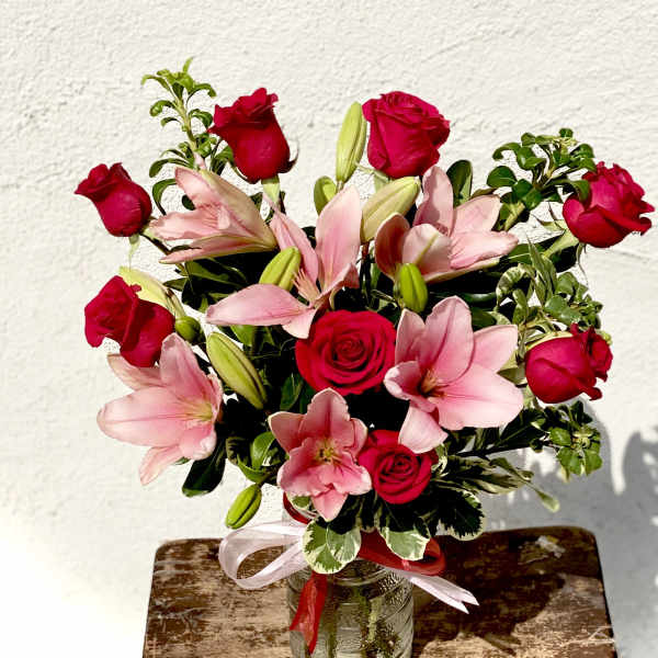 Bouquet of red roses and pink lilies in a glass vase