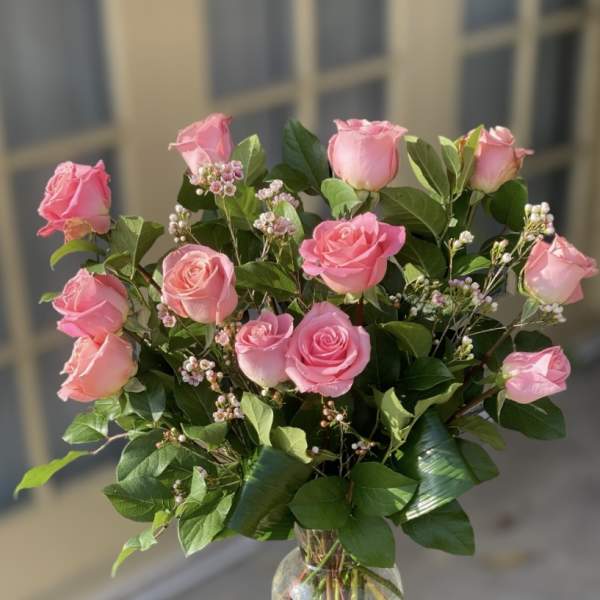 Pink roses arranged in a clear glass vase