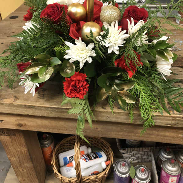 Holiday floral centerpiece with red roses, white daisies, and gold ornaments