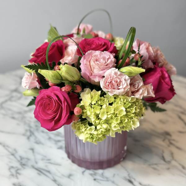 Pink roses and pale green hydrangea in a pink vase