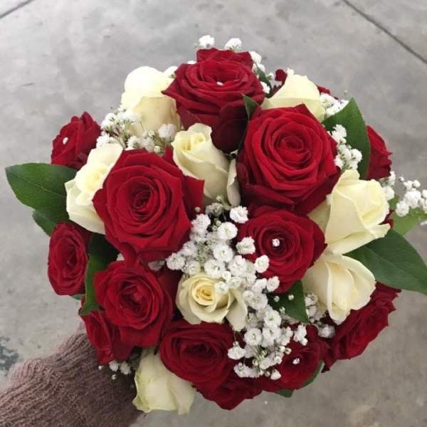 Handheld bouquet of red and white roses with baby's breath