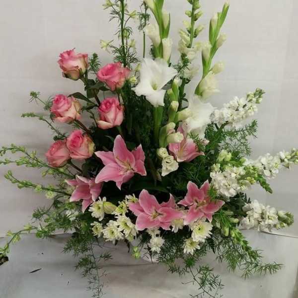 Tall floral arrangement with pink roses, pink lilies, and white gladiolus
