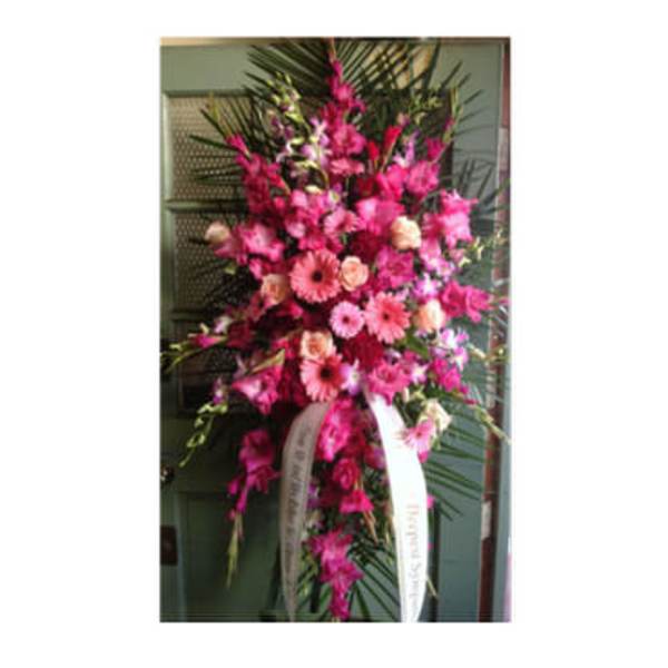Tall pink floral standing spray with ribbon streamers