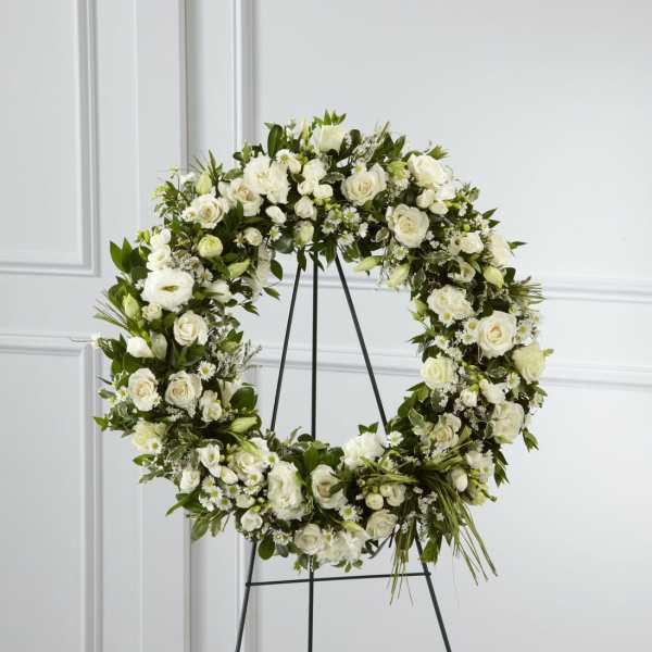 White floral wreath on a black stand