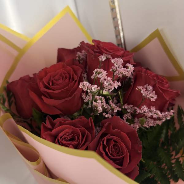 Bouquet of red roses with pink filler flowers in pink wrapping
