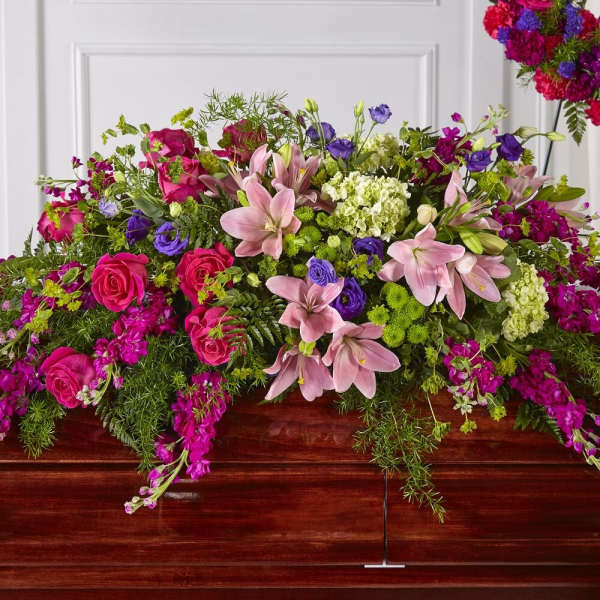 Large pink, purple, and white floral casket spray