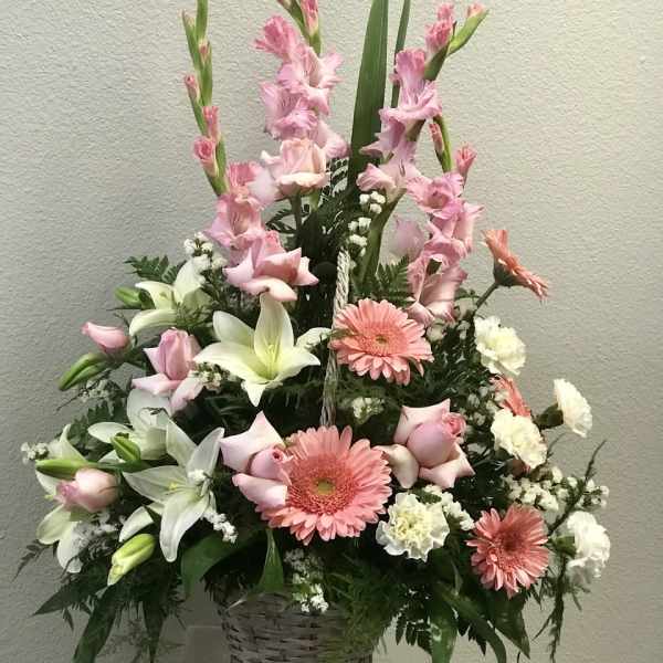 Tall pink and white flower arrangement with lilies, roses, and gerberas in a white wicker basket