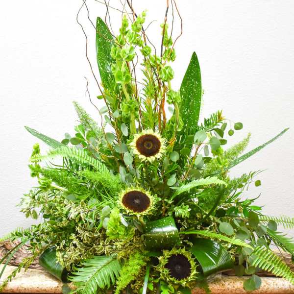 Tall green arrangement with sunflowers and fern-like foliage