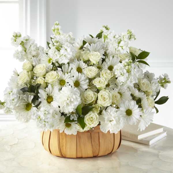 White roses and daisies in a woven basket