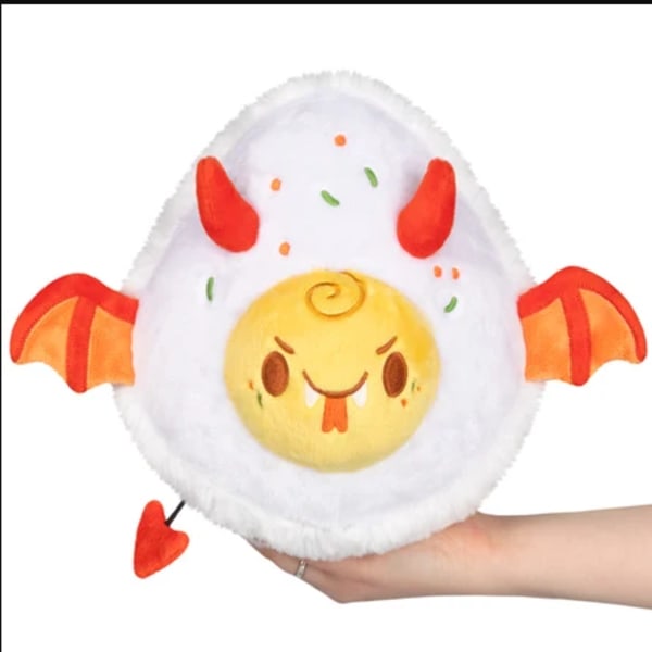 Plush round white and yellow monster toy with red wings and horns