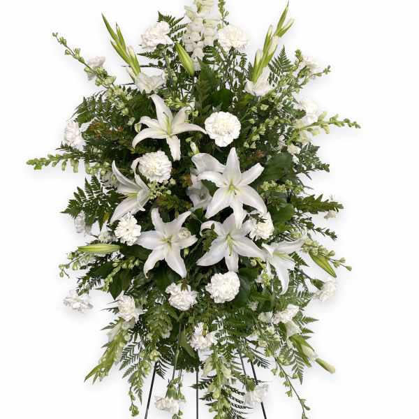 White lilies and carnations in a standing spray on an easel
