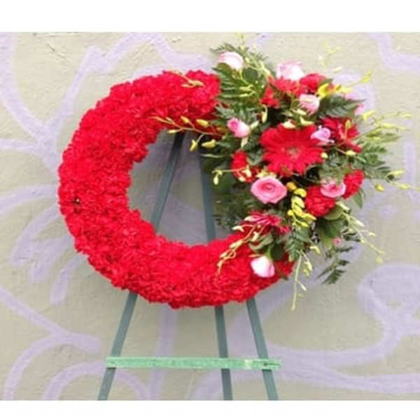 Red floral wreath on an easel with pink and white accents