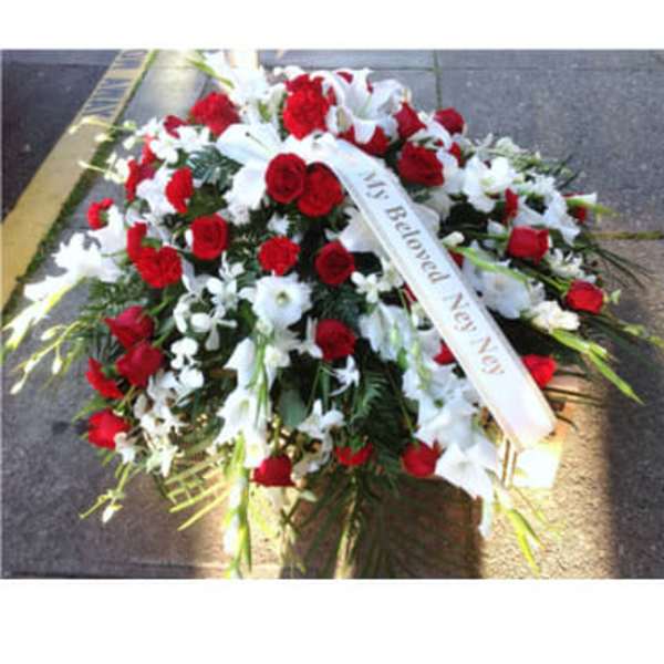 Red and white funeral spray with a memorial ribbon