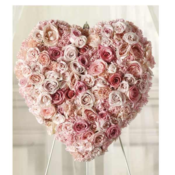 Heart-shaped arrangement of pink and blush roses on a stand