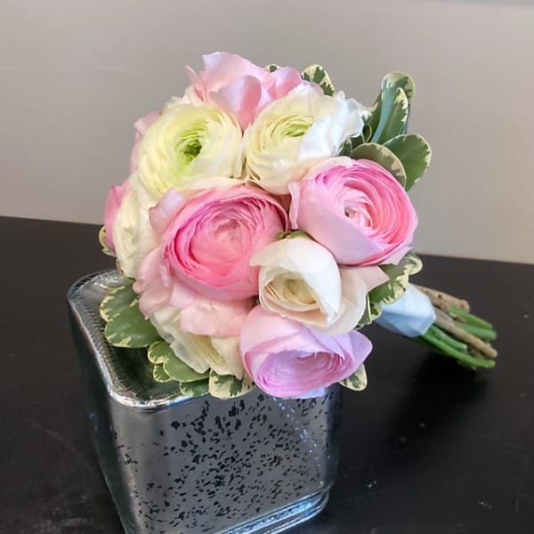 Pink and white ranunculus bouquet in a square glass vase