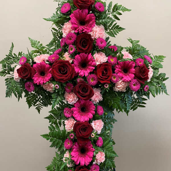 Large floral cross with red roses, pink gerberas, and carnations