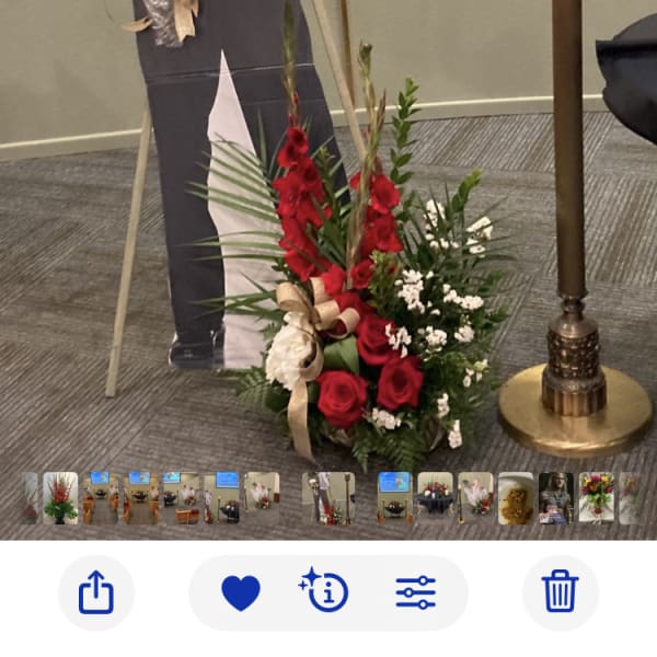 Red and white floral spray beside a cardboard cutout and candle