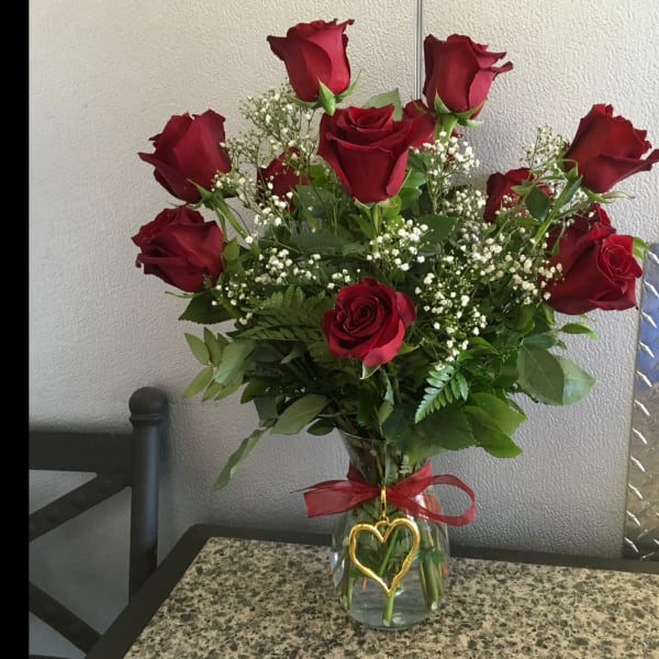 Bouquet of red roses in a glass vase with a red ribbon