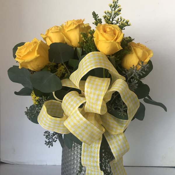 Yellow roses in a silver vase with a large gingham ribbon