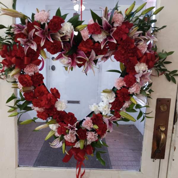 Heart-shaped floral wreath with red, pink, and white flowers