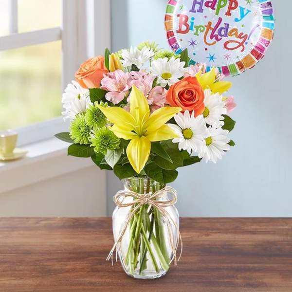 Mixed bouquet in a glass jar with a happy birthday balloon