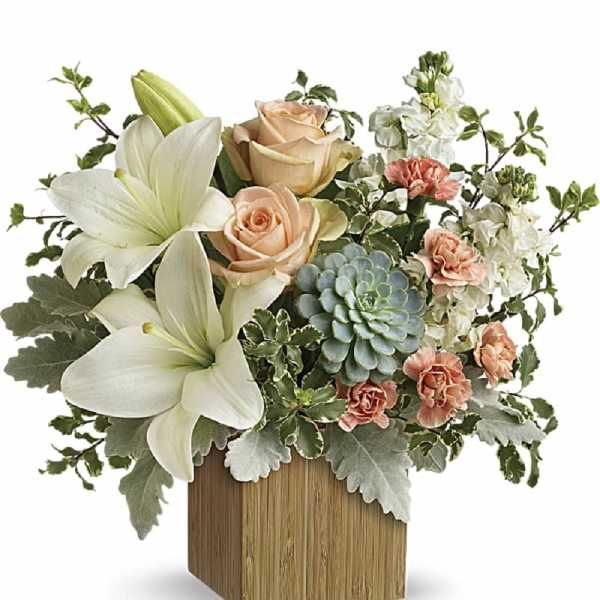 Flower arrangement with white lilies, peach roses, and a succulent in a wooden vase