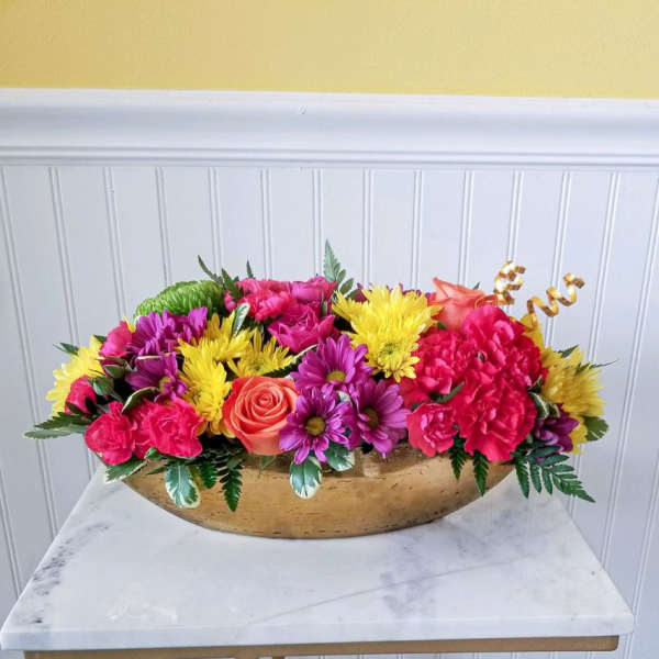 Bright mixed flower arrangement in a gold bowl