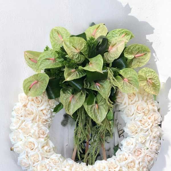 Heart-shaped floral wreath with cream roses and pale green anthuriums