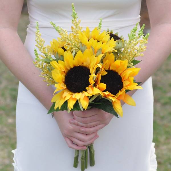 Bride holding a bouquet of yellow sunflowers with airy filler flowers