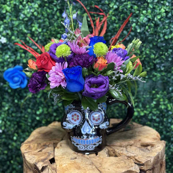 Colorful bouquet in a black skull mug on a wooden stand