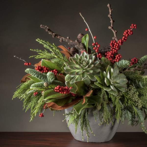 Succulent arrangement with red berries in a gray vase