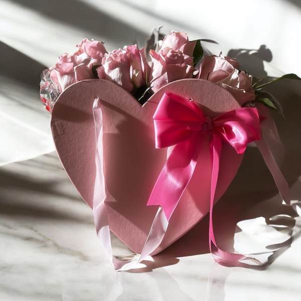 Pink roses in a heart-shaped gift box with a satin bow
