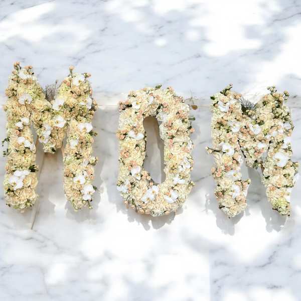 Floral letters spelling "MOM" in cream and white blooms