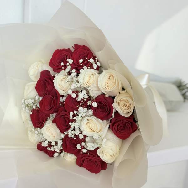 Bouquet of red and white roses wrapped in cream paper