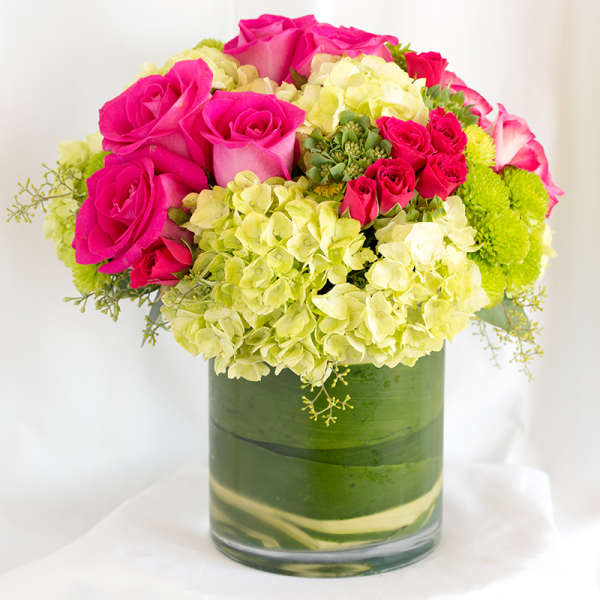 Pink roses and pale green hydrangeas in a glass vase