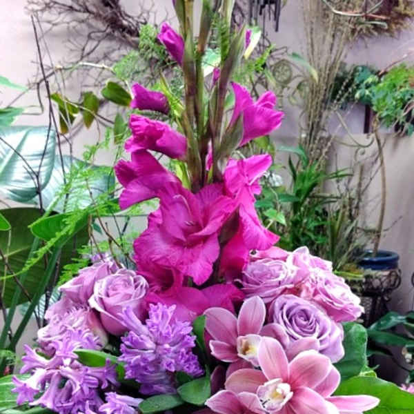 Tall pink and lavender floral arrangement in a clear vase