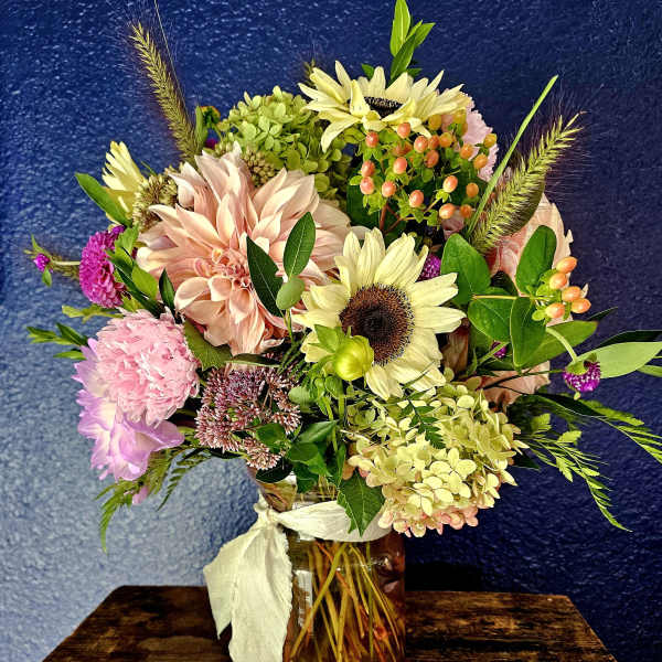 Mixed bouquet in a glass jar vase with pale pink and cream blooms
