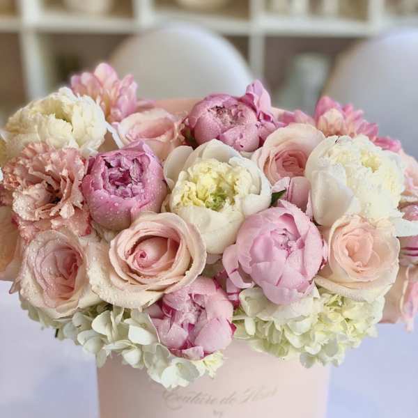 Pink and white bouquet of peonies and roses in a pale pink box