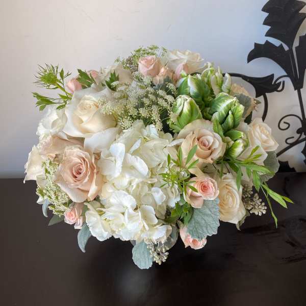 Bouquet of pale roses and white hydrangeas with green accents