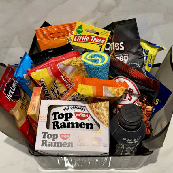 Gift basket filled with snack bags, ramen, and a drink bottle