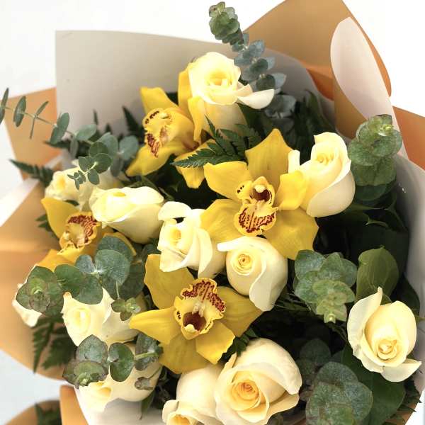 Bouquet of yellow orchids and cream roses with eucalyptus