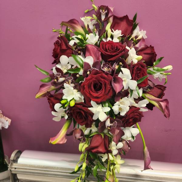 Cascade bouquet of red roses, white orchids, and burgundy calla lilies