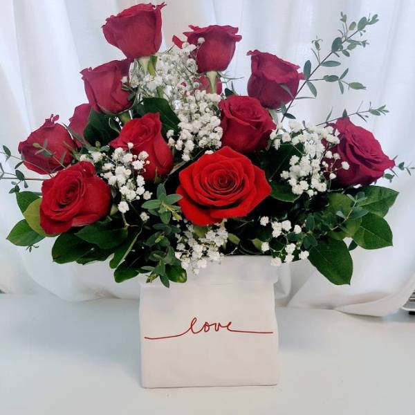Red roses arranged in a white box with baby's breath