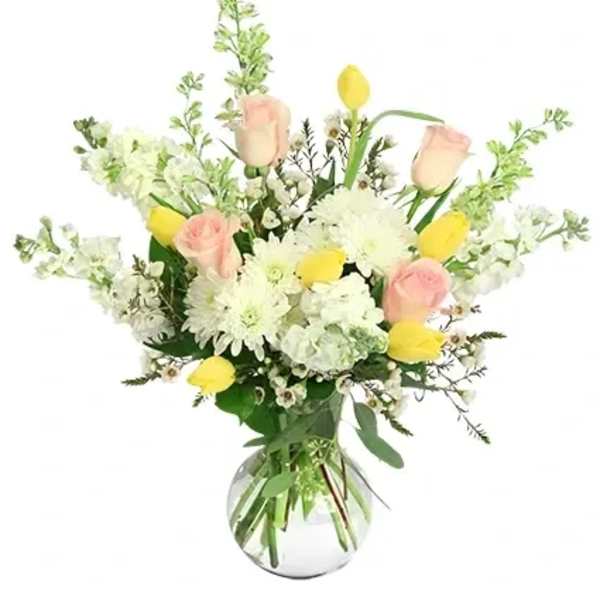 Bouquet of pink roses, white daisies, and yellow tulips in a glass vase