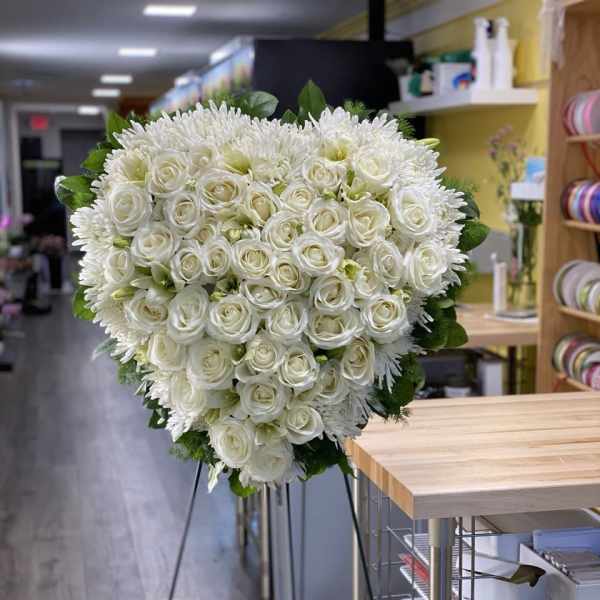 Large white rose and chrysanthemum standing spray on an easel