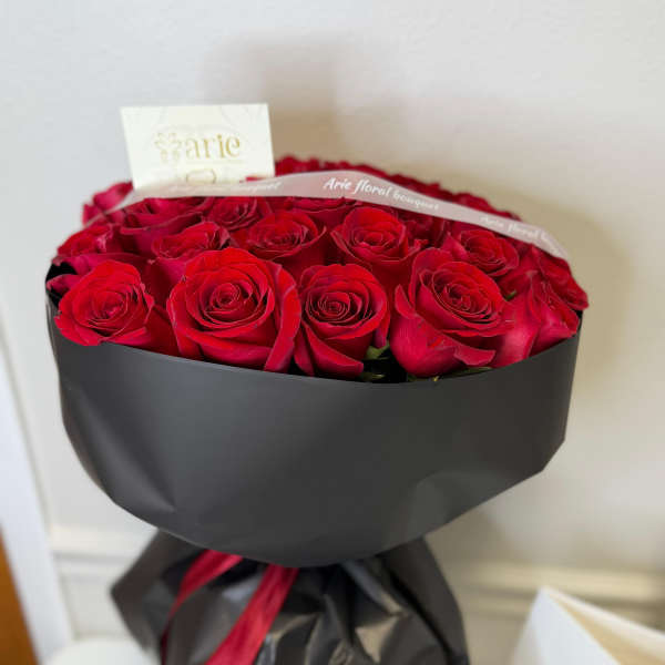 Bouquet of red roses wrapped in black paper