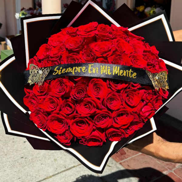 Large bouquet of red roses with a black ribbon banner