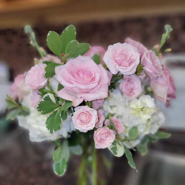 Pink roses and white hydrangeas in a glass vase